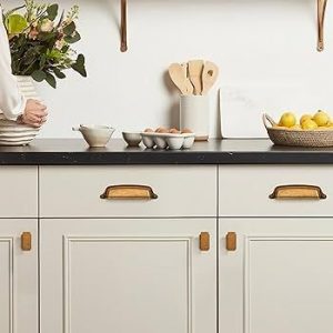 Klassiska handtag i mässing på vita köksluckor och lådor.